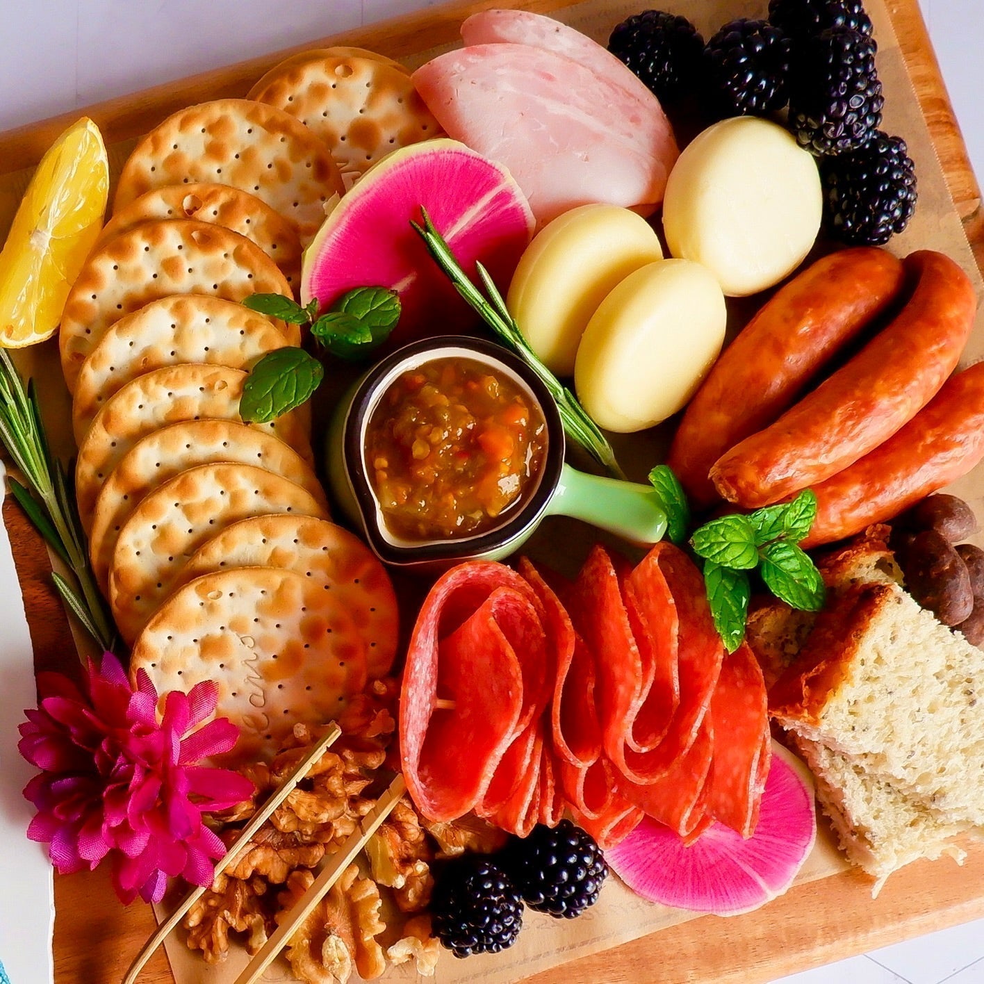 Alexandra’s Pikliz® Spicy Pepper Relish served on a charcuterie board with meats, cheeses, and accompaniments, highlighting texture and bold Haitian-Caribbean flavor